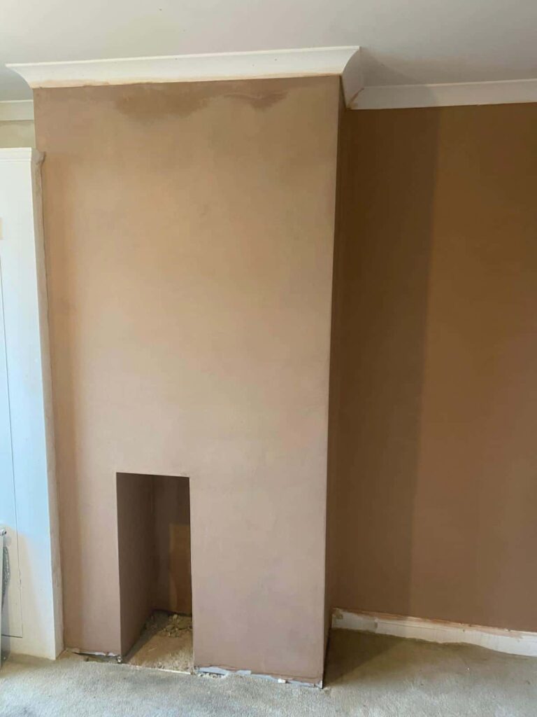 This is a photo of a chimney place in a living room which has just been newly plastered