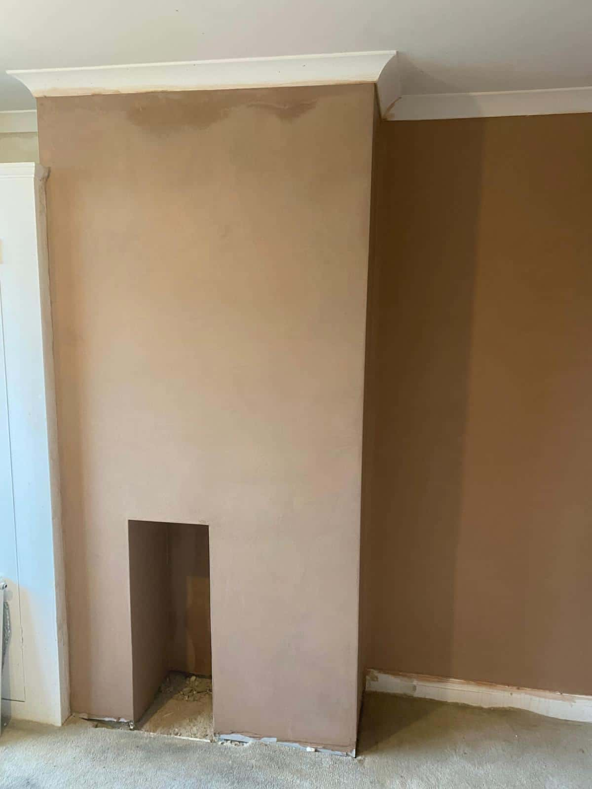 This is a photo of a hallway where the walls and ceiling are being stripped back, and re-wiring is being carried out, ready for bonding and re-plastering