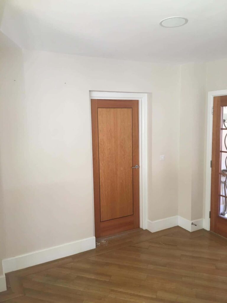 This is a photo of a door in a hallway that is just about to be removed, boarded up and plastered