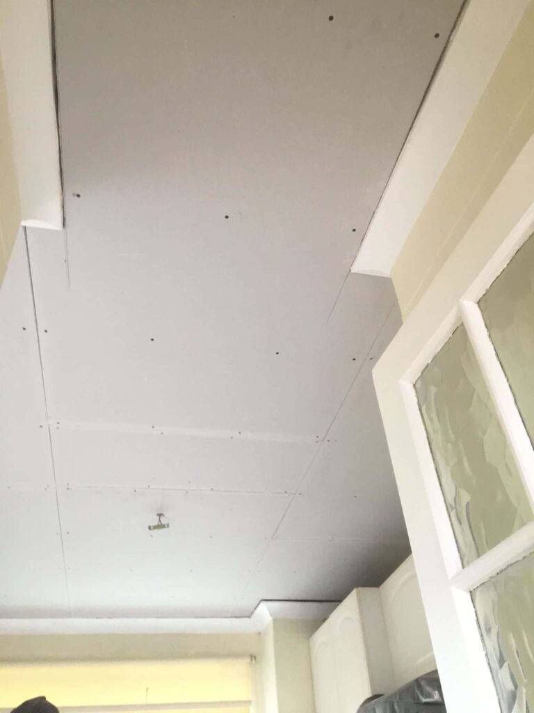 This is a photo of a ceiling that has new plasterboard installed after a leak. It is now ready to be skimmed